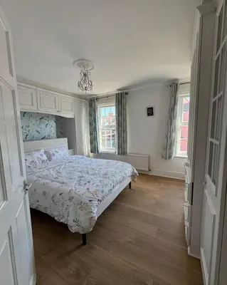 a bedroom with a bed and two windows at Three Bees in Hythe