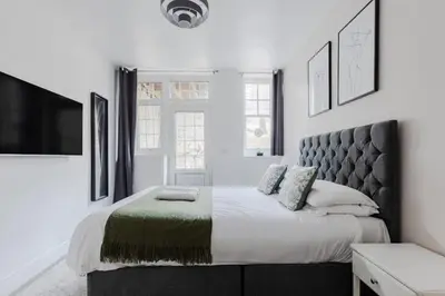 a bedroom with a large bed and a tv at The Regency | Seafront Lux Apartments! in Southend-on-Sea
