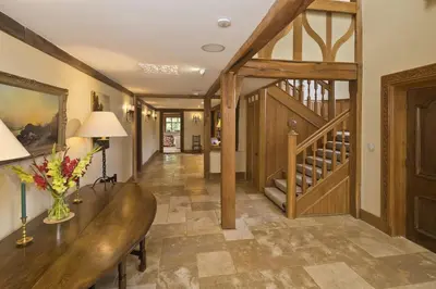 a hallway with a wooden table and a staircase at Martley Hall Estate by Group Retreats in Woodbridge