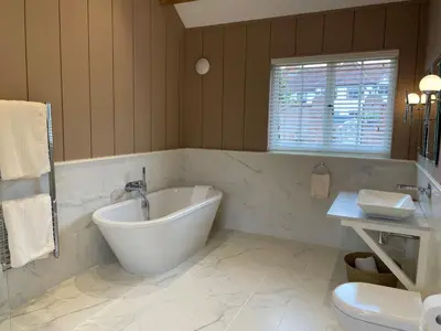 a bathroom with a tub and a toilet and a sink at Martley Hall Estate by Group Retreats in Woodbridge