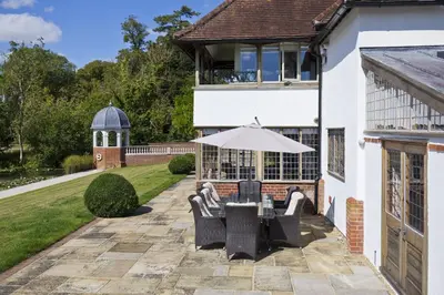 a patio with a table and chairs and an umbrella at Martley Hall Estate by Group Retreats in Woodbridge