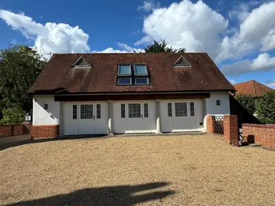 a house with white garage doors and a driveway at Martley Hall Estate by Group Retreats in Woodbridge