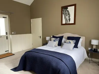 a bedroom with a bed with a blue and white blanket at Martley Hall Estate by Group Retreats in Woodbridge