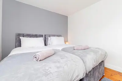 a bedroom with two beds with pillows on them at Beautiful 3 Bedroom Home with Parking & Garden in Colchester