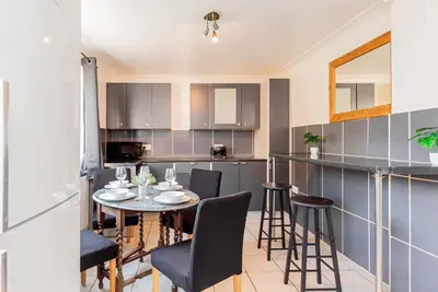 a kitchen with a table and chairs in a room at Beautiful 3 Bedroom Home with Parking & Garden in Colchester