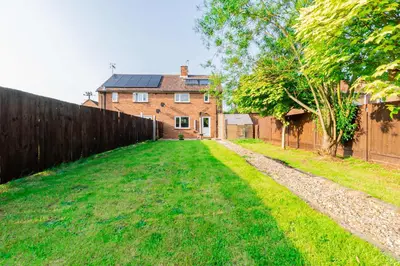 a yard with a fence and a house at Beautiful 3 Bedroom Home with Parking & Garden in Colchester
