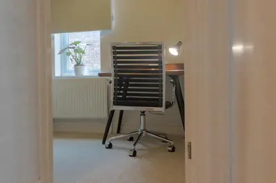 an office chair sitting at a desk in a room at Cambridge Charming 2 Bedroom Home I Rustic Floors & Office I Parking in Milton