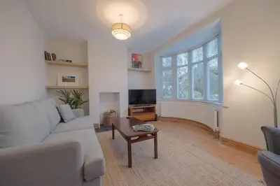 a living room with a couch and a table at Cambridge Charming 2 Bedroom Home I Rustic Floors & Office I Parking in Milton