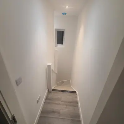a hallway with white walls and a stair case at 3 Bedroom House Ingatestone in Freyerning