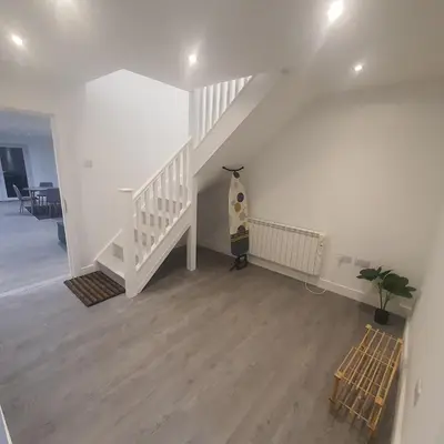 a white room with a staircase with a penguin statue at 3 Bedroom House Ingatestone in Freyerning