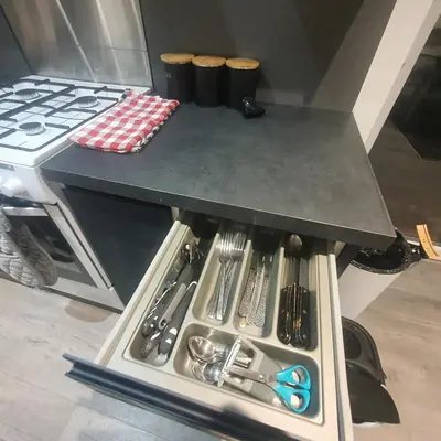 a drawer under a counter with a table with utensils at 3 Bedroom House Ingatestone in Freyerning