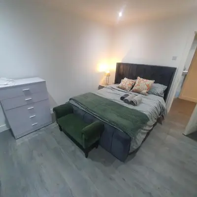 a bedroom with a large bed with a dresser at 3 Bedroom House Ingatestone in Freyerning