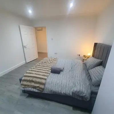 a bedroom with a large bed and a couch at 3 Bedroom House Ingatestone in Freyerning