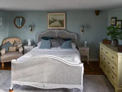 a bedroom with a white bed and a chair at Hill House in Colchester