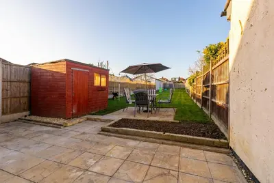 a patio with a table and an umbrella at Spacious 3-Bed Home for 8 | Free Parking & Garden in Havering atte Bower