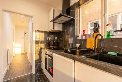 a kitchen with a sink and a counter top at Spacious 3-Bed Home for 8 | Free Parking & Garden in Havering atte Bower