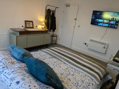 a bedroom with a bed with pillows and a tv on the wall at Digby house flat 2 in West Mersea