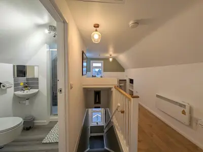 a bathroom with a staircase and a sink and a toilet at Digby house flat 2 in West Mersea
