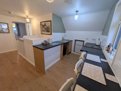 a kitchen with a counter and a table with chairs at Digby house flat 2 in West Mersea