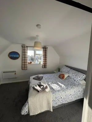 a bedroom with a bed with a dog laying on it at Digby house flat 2 in West Mersea
