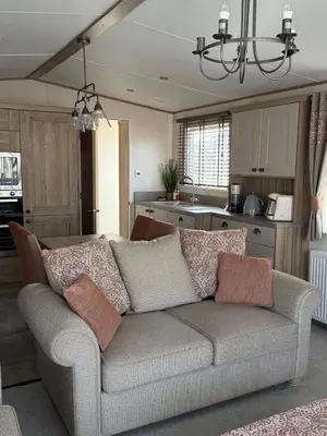 a living room with a couch and a kitchen at Bishops Beach Stays in Walton-on-the-Naze