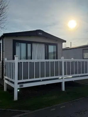 a house with a white fence and a porch at Bishops Beach Stays in Walton-on-the-Naze