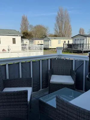 a balcony with two chairs and a table and some houses at Bishops Beach Stays in Walton-on-the-Naze
