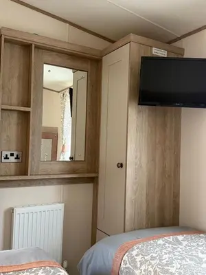 a bedroom with a flat screen tv and a bed at Bishops Beach Stays in Walton-on-the-Naze