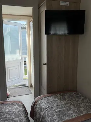 a bedroom with a bed and a door with a window at Bishops Beach Stays in Walton-on-the-Naze