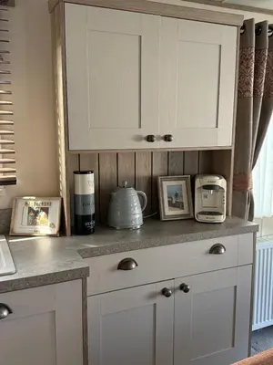 a kitchen counter with a white cabinet and some pictures at Bishops Beach Stays in Walton-on-the-Naze