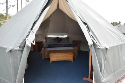 a bedroom with a bed in a canvas tent at Rum Bridge Glamping and Fishing Resort in Clare