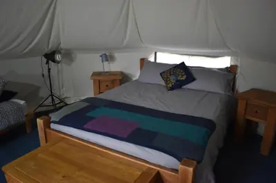 a bedroom with a bed in a tent at Rum Bridge Glamping and Fishing Resort in Clare