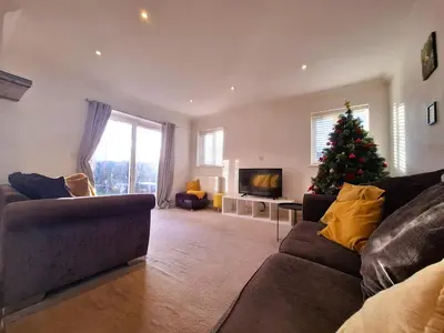 a living room with a christmas tree and a couch at Modern home close to amenities and transport links in Wymondham