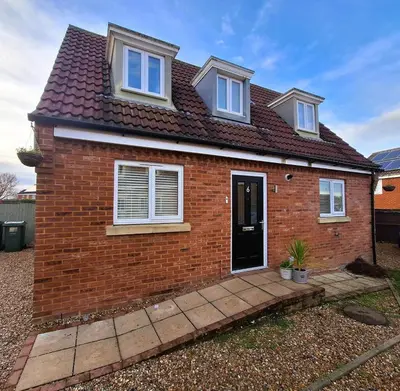 a red brick house with a black door at Modern home close to amenities and transport links in Wymondham