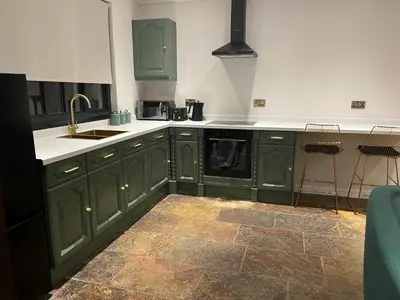 a kitchen with green cabinets and a sink at The Croft Farmhouse Apartments in East Horndon