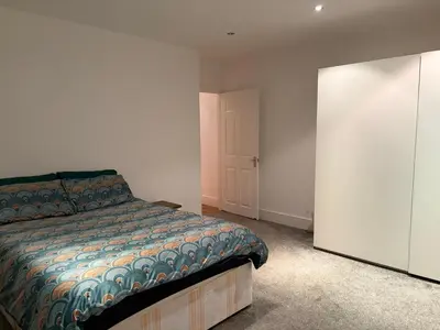 a bedroom with a bed and a closet and a door at The Croft Farmhouse Apartments in East Horndon