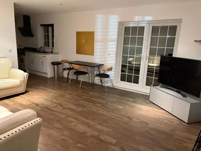 a living room with a table and a television at The Croft Farmhouse Apartments in East Horndon