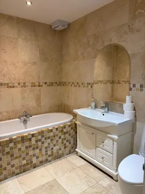 a bathroom with a tub and a sink and a toilet at The Croft Farmhouse Apartments in East Horndon