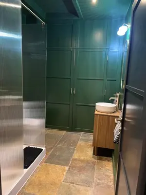 a bathroom with green cabinets and a sink and a shower at The Croft Farmhouse Apartments in East Horndon