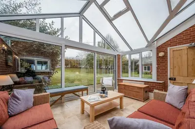 a conservatory with a glass roof with a living room at 1 Box Iron Cottage, Shotley in Shotley