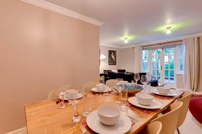 a dining room with a wooden table and chairs at Stylish Modern Home in City Centre Free Parking - Pass the Keys in Cambridge