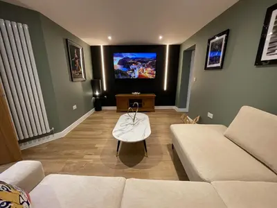 a living room with a couch and a flat screen tv at Luxury new build house nearr Science and Business parks in Cambridge