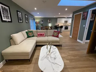 a living room with a couch and a table at Luxury new build house nearr Science and Business parks in Cambridge