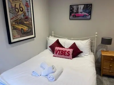 a bed with two towels and a pillow with the word wishes at Luxury new build house nearr Science and Business parks in Cambridge