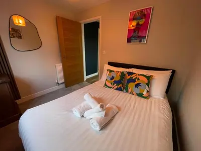 a bedroom with a bed with two stuffed animals on it at Luxury new build house nearr Science and Business parks in Cambridge