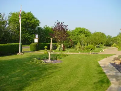 a park with a flag and a grass field at Acreland Green in Pleshey