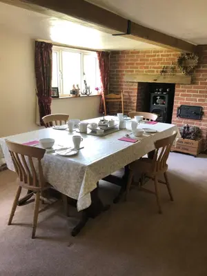 a dining room table with chairs and a table cloth at Acreland Green in Pleshey