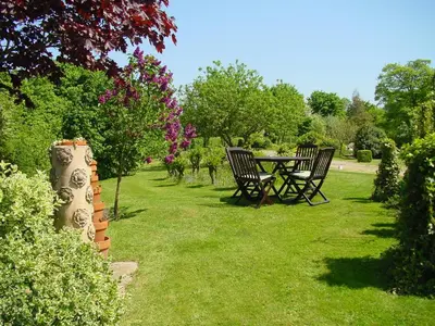 a table and chairs in a yard with grass at Acreland Green in Pleshey