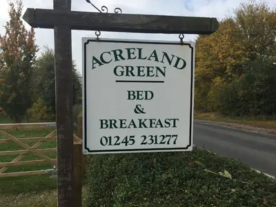 a sign for a green bed and breakfast on a road at Acreland Green in Pleshey