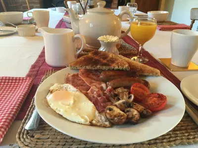 a plate of breakfast food with eggs bacon and toast at Acreland Green in Pleshey
